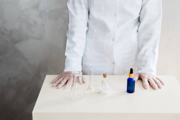 Cosmetologist's hands and glass jar stock photo