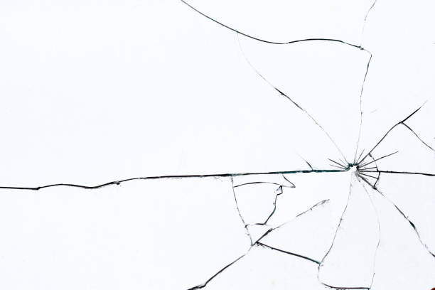 bullet hole in broken glass on a white background. shards of glass - fracture imagens e fotografias de stock