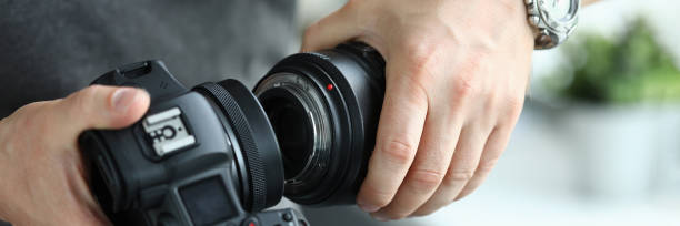 istock Male hands putting on modern digital camera professional lens 1351889672