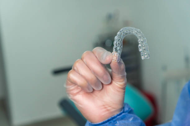 istock Female dentist holding clear dental aligners 1351891375