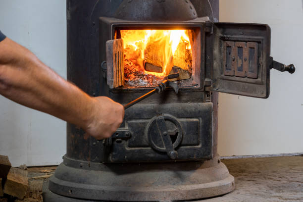 istock Man putting log to wood burning stove 1351891384