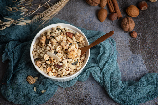 Protein crisp with raisins, walnuts, almonds, hazelnuts, coconut on a decorative chip blue background. Healthy protein, vegan breakfast.