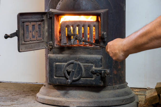 istock Man putting log to wood burning stove 1351891952
