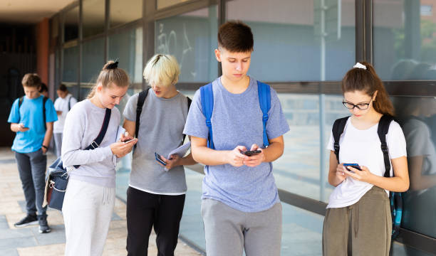 istock Interested teenagers using phones on college campus 1351892006