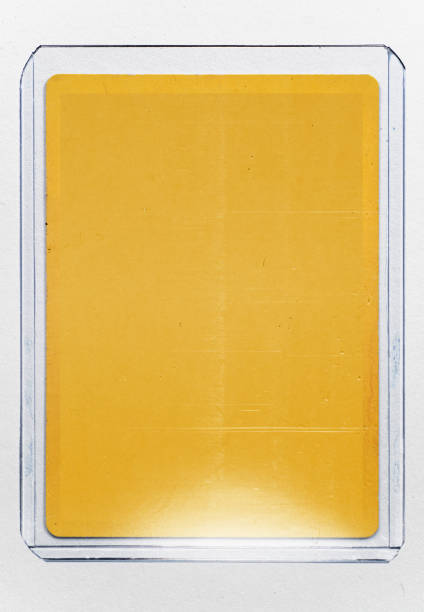 empty yellow trading card with no content or picture behind transparent plastic top loader case on white paper background.