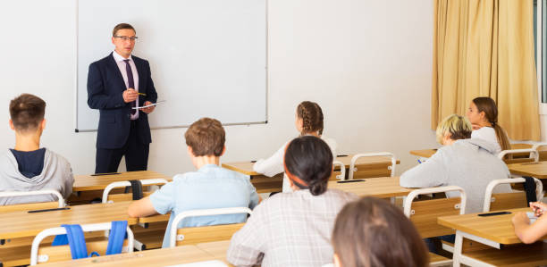 istock Adult teacher is giving lecture for students in class 1351892540