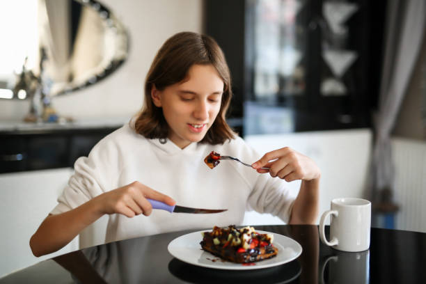 girl eating strawberry banana waffle
