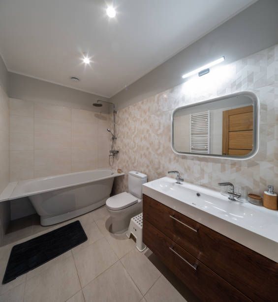 istock Modern interior of bathroom. White sink, toilet, bath. Tile floor. 1351895485