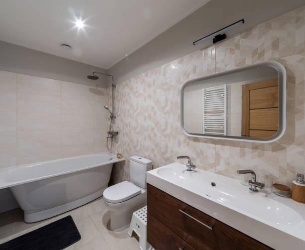 istock Modern interior of bathroom. White sink, toilet, bath. Tile floor. 1351895593