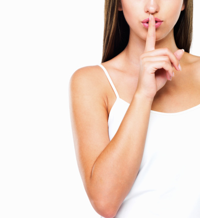 Cropped image of beautiful woman with finger on her lips telling you to hush - Copyspace