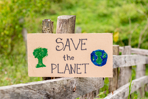 SAVE THE PLANET, poster asking to save our planet isolated on a natural background of wood and vegetation.