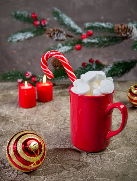 istock Hot winter drink: chocolate with marshmallow and caramel cane in red mug with . Christmas time 1351898378