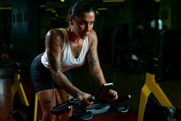 aula de fiação na academia - spinning instructor exercising gym - fotografias e filmes do acervo