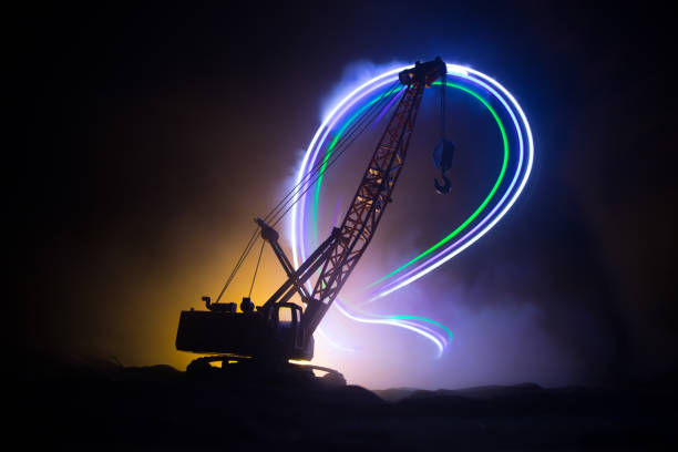 istock Abstract Industrial background with construction crane silhouette over amazing night sky with fog and backlight. Tower crane against the foggy sky at night. 1351910508