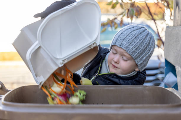 Little Boy Composting at Home and Emptying Food Waste in Composting Bin