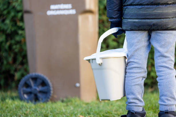istock Little Boy Composting at Home and Bringing Food Waste to Composting Bin 1351913935