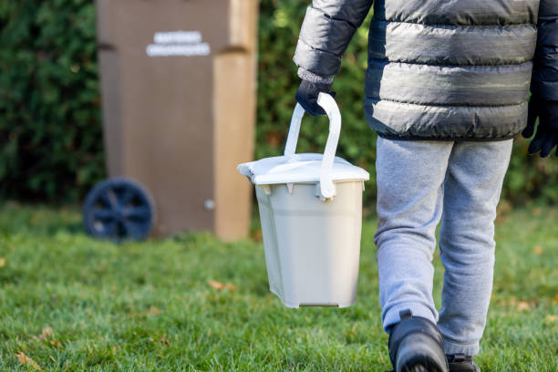istock Little Boy Composting at Home and Bringing Food Waste to Composting Bin 1351914634