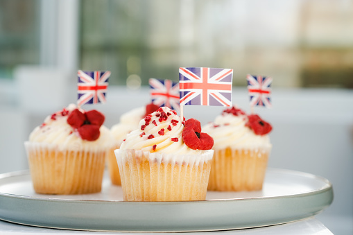 Cupcake with British Union jack flag and poppy flower. Remembrance Day. Selective focus, copy space