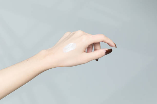 istock Close-up view of hands applying cream 1351935392