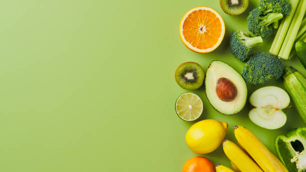 istock Vegetables and fruits frame on green background horizontal flat lay copy space 1351935455
