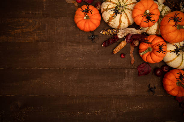 istock Halloween themed composition with copy space. Pumpkins, spiders, corn on dark rustic wooden background. Halloween background top view. 1351941541
