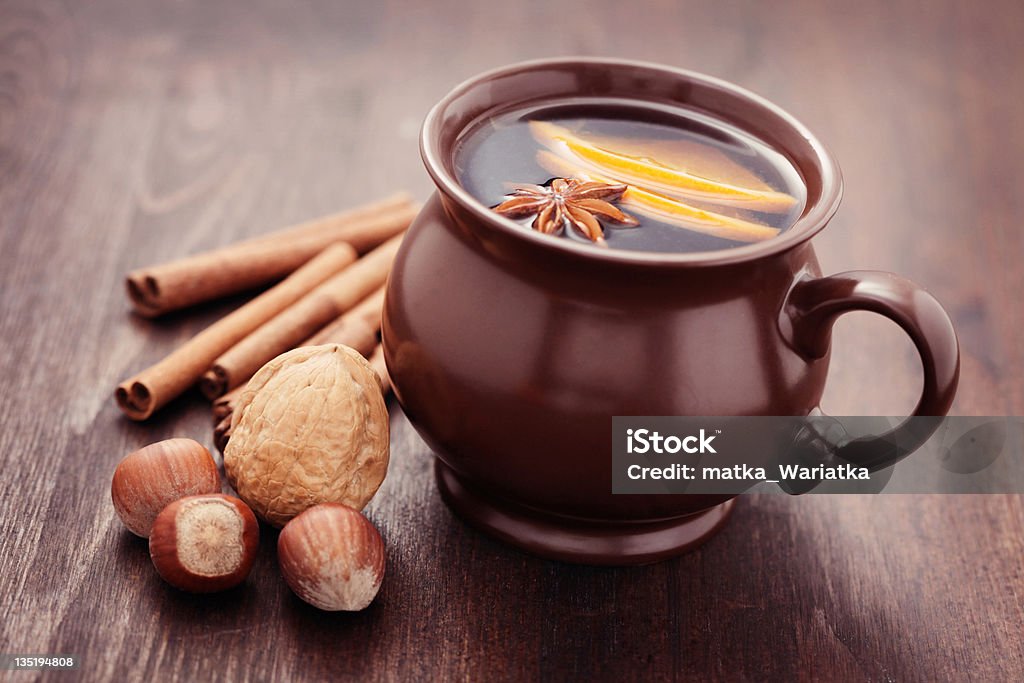 A mug of hot cider with nuts and cinnamon sticks delicious hot wine with cinnamon - food and drink Alcohol - Drink Stock Photo