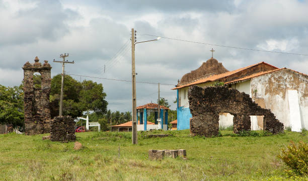 Ruins of the Church of Our Lady of the Rosary, attributed to the Jesuit Mission, or according to other sources, to the Franciscan Mission, Church of Our Lady of the Rosary (1905) and bandstand. Set plan. Vila de Joanes, Salvaterra, Marajó Island, Pará. Medium plane. ruinas de la iglesia de nuestra señora del rosario, atribuidas a la
misión jesuita, o según otras fuentes, a la misión franciscana, iglesia de nuestra señora del rosario (1905) y quiosco de música. disparo medio. joanes village, salvaterra, isla de m