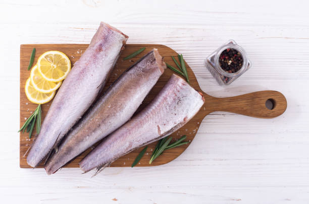 Raw hake on wooden background Raw hake on wooden background . ready to cooking hake stock pictures, royalty-free photos & images