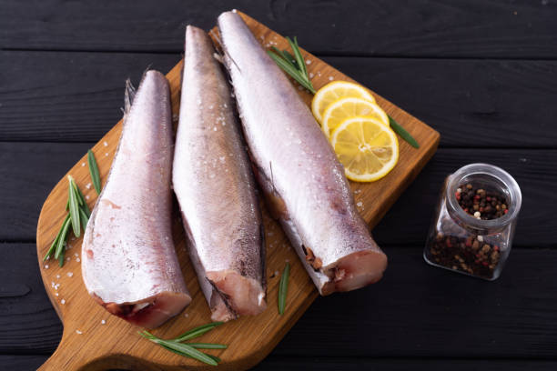istock Raw hake on wooden background 1351949398