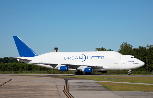 North Charleston, South Carolina, USA - September 23, 2021: One of Boeings Dreamlifter aircraft, a modified 747, arrives at the Boeing production facility at the Charleston International Airport.