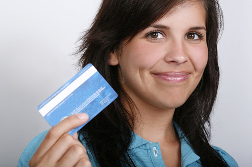 Close up of attractive young woman holding credit card.