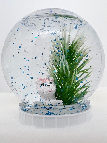 Christmas decoration of a white terrier under an evergreen
