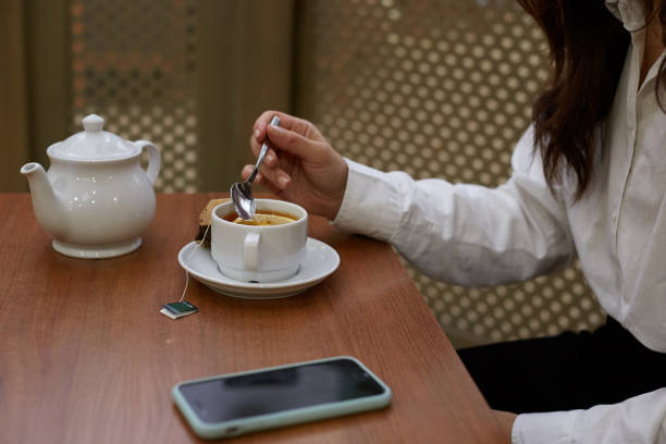 istock Delicious tea party. A girl sitting at a table drinking tea from a cup 1351956704