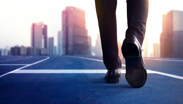 開始、競争の概念。ビジネスマンの低いセクションは、トラックを実行し、新しい挑戦に進む上でスタートラインにステップ - 挑戦 ストックフォトと画像