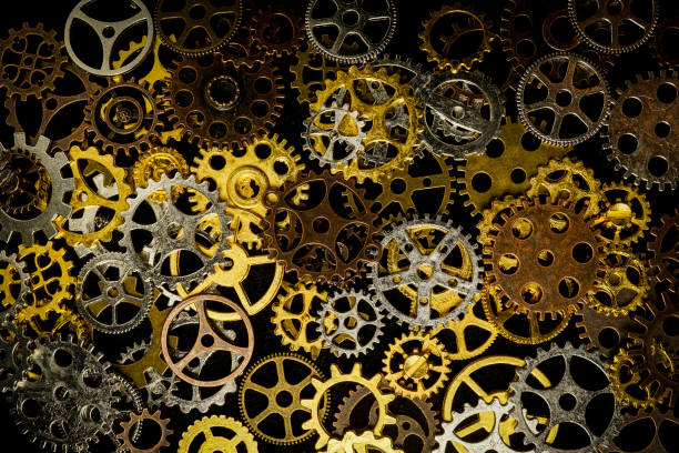 istock Cogs and watch pieces on black background metal wheels 1351960845