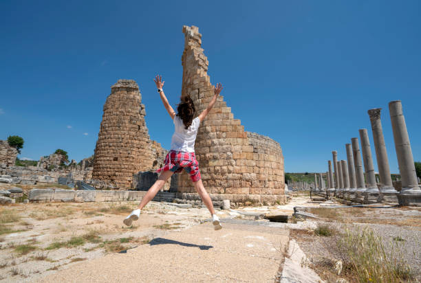 istock Female tourist having fun in Perge and taking picture, Analya,Turkey 1351961943