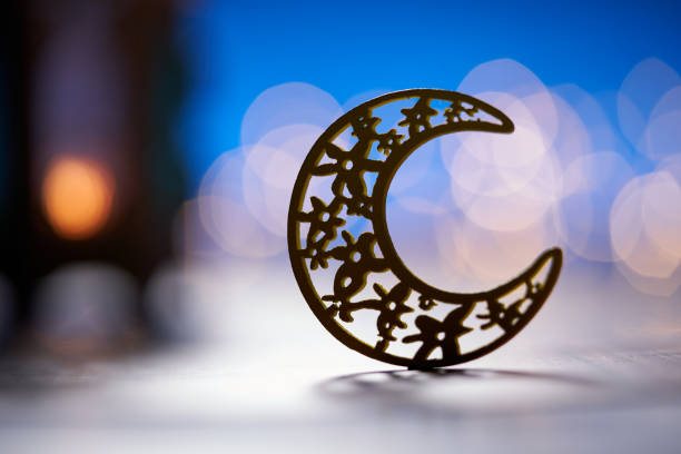 Ornamental Arabic lantern with burning candle glowing at night.