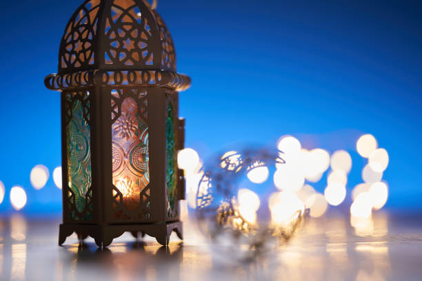 istock Ornamental Arabic lantern with burning candle glowing at night. 1351963649