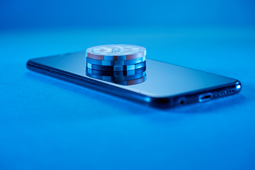 poker chips on top of smart phone display- online gambling