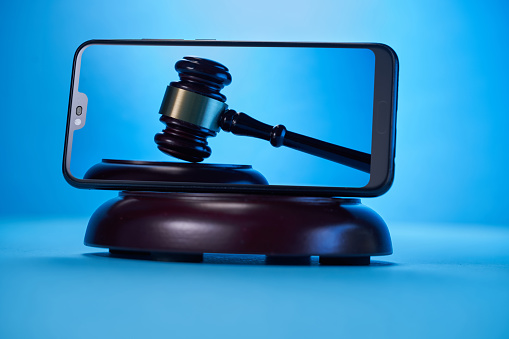 gavel hammer  with smartphone on blue background. Justice and law concept.