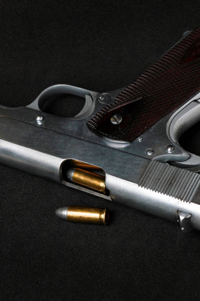 istock Automatic white gun stainless steel pistol weapon model m1911 with real bullet ammo head in black background 1351966113