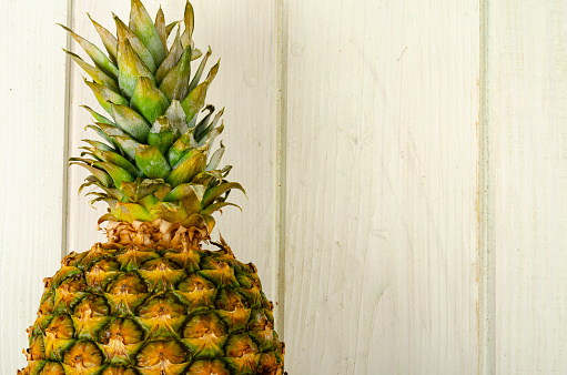 Exotic fruits. Ripe sweet ripe pineapple on wooden background. Photo