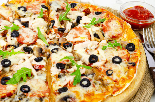 istock pizza with salami, ham and mozzarella on wooden table. 1351968432