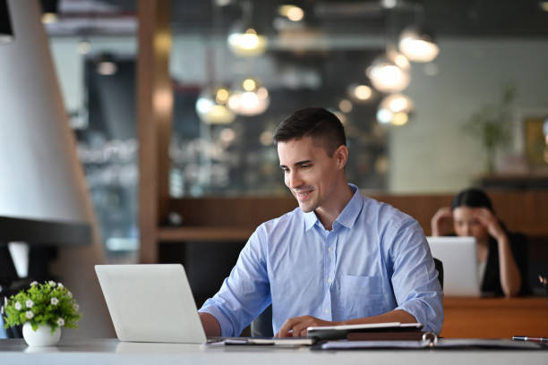 istock Handsome businessman working with laptop computer in modern office. 1351969502