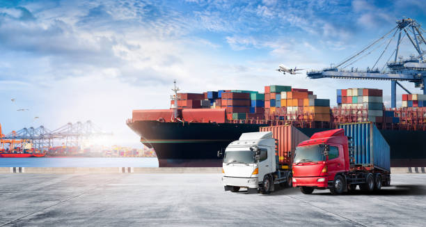Container cargo freight ship during discharging at industrial port and move containers to container yard by trucks, cargo plane, logistic import export background and transport industry concept stock photo