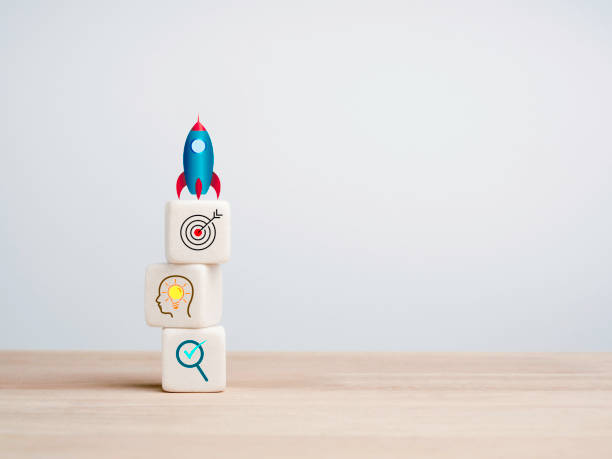 istock Business startup with growth success process for leadership concept. The rocket beside the white cube blocks stacks with business strategy icons on wooden table on white background with copy space. 1351977849