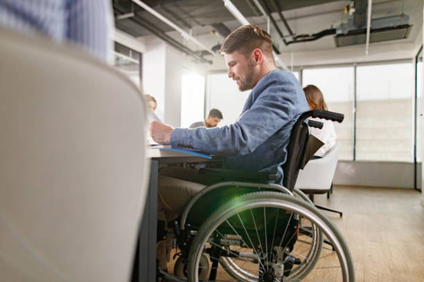 istock Disabled businessman working on paperwork during a meeting in the office. 1351978834