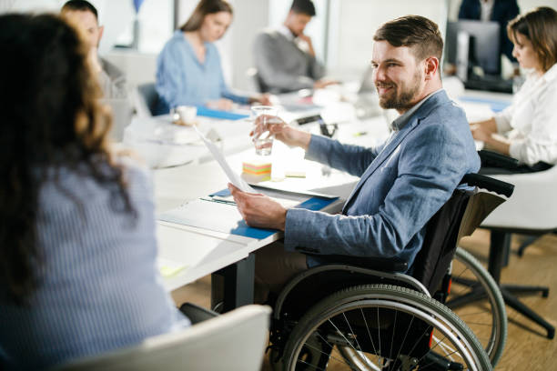 istock Happy disabled businessman working on paperwork with his colleague. 1351978859