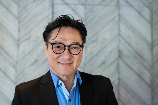 Portrait of senior Asian entrepreneur businessman wearing eyeglasses and  looking at camera