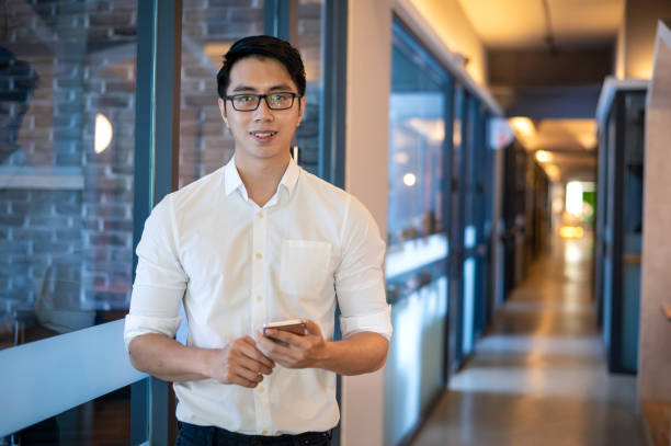 istock Young smiling Asian male business executive in modern office 1351979882